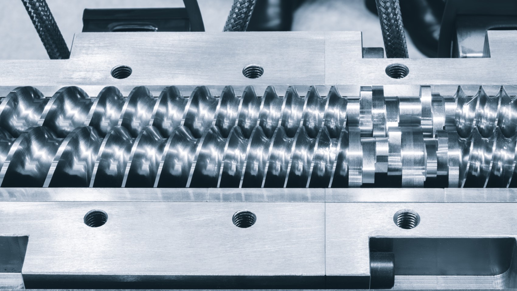 Twin extruder screws exposed in an open extruder barrel
