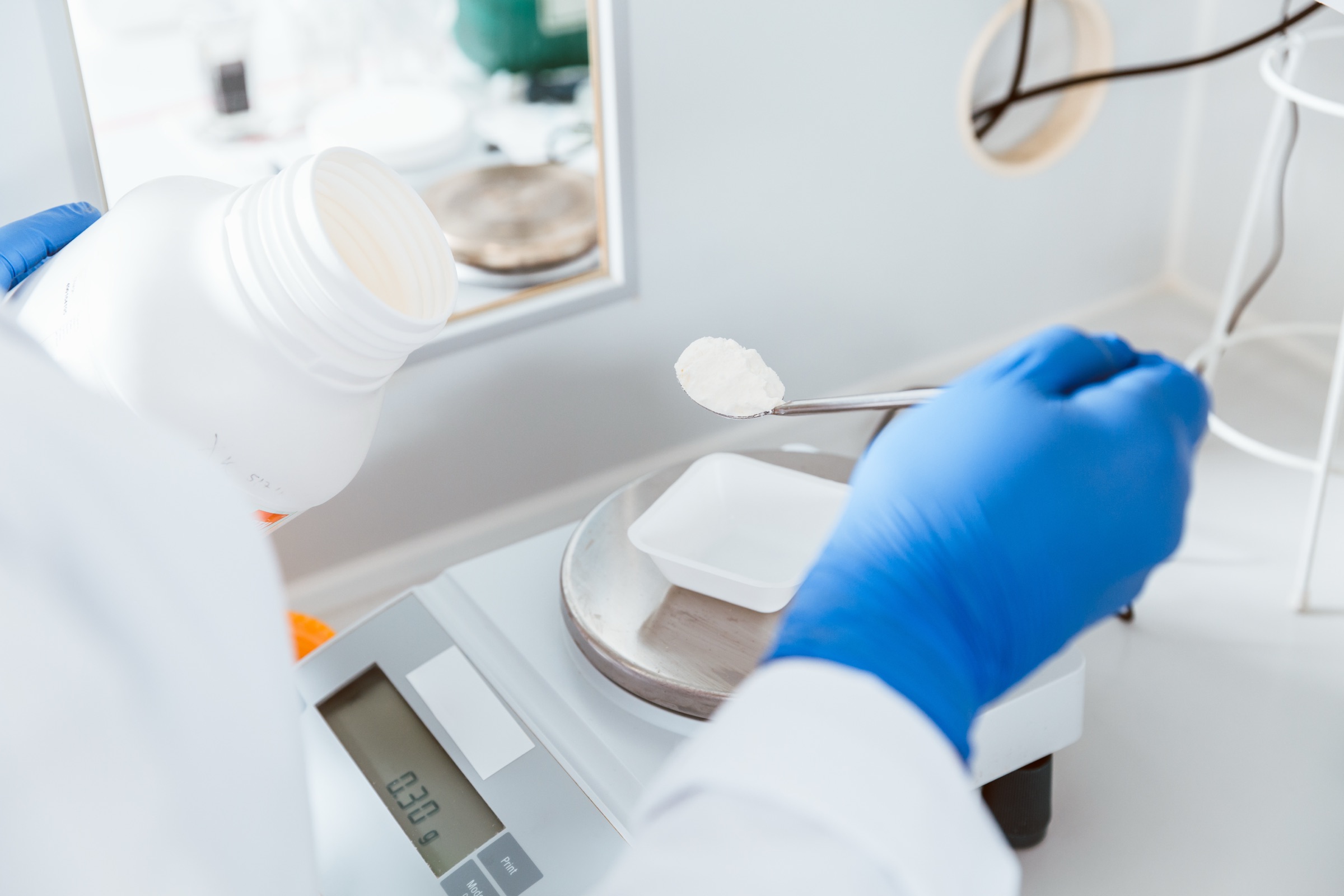 Weighing a raw material on a lab balance during formulation work