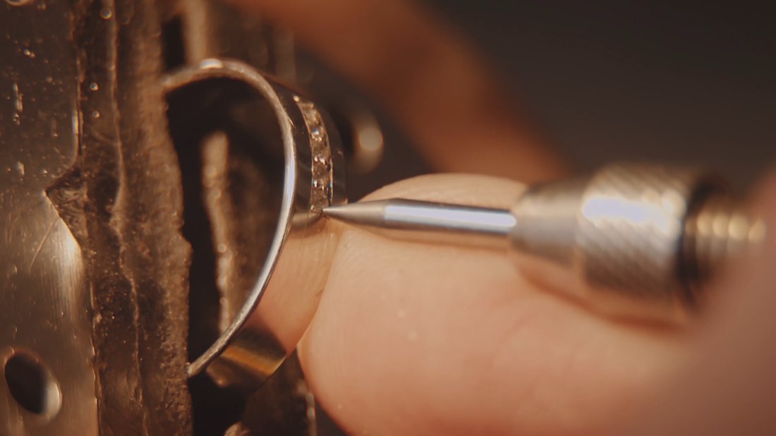 A jeweler setting a stone in a ring, held with shellac cement