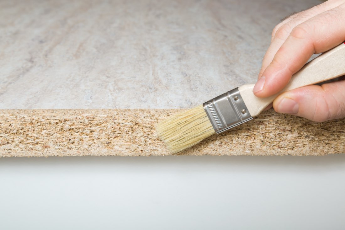 Brushing a sealer onto wood, a stain-blocking primer application